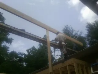 Carpenter setting a ridge beam over a new addition frame — Ice Dam Removal by Roofing Brothers in South Milford