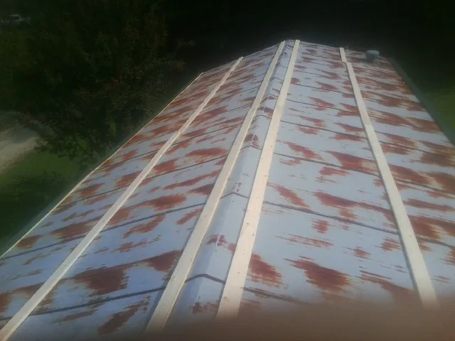 Rusted metal roof panels with new wood purlins before replacement — Storm Damage Roof Repair in South Milford by Roofing Brothers