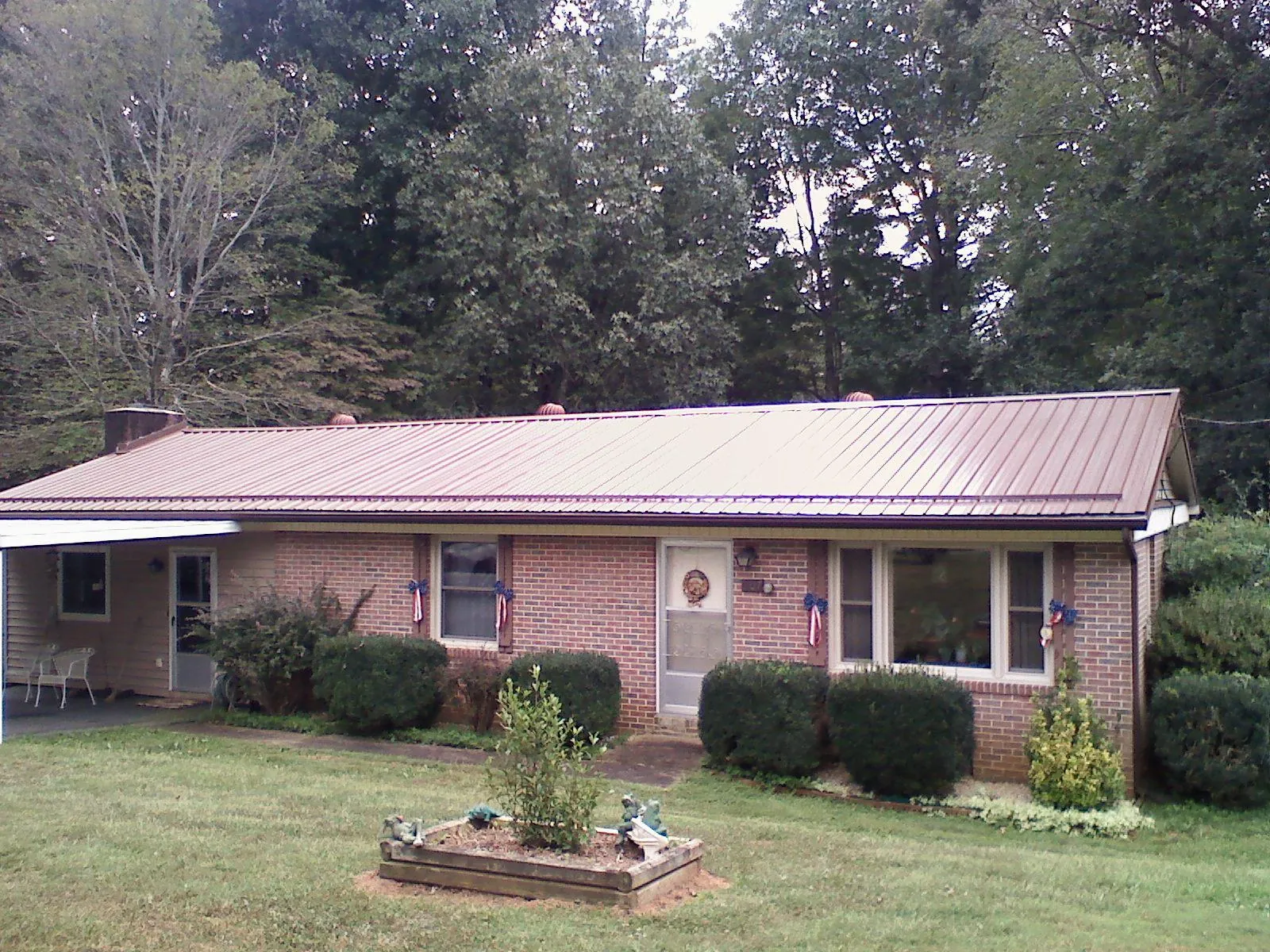 Bronze metal roof on a brick ranch home with a carport in South Milford