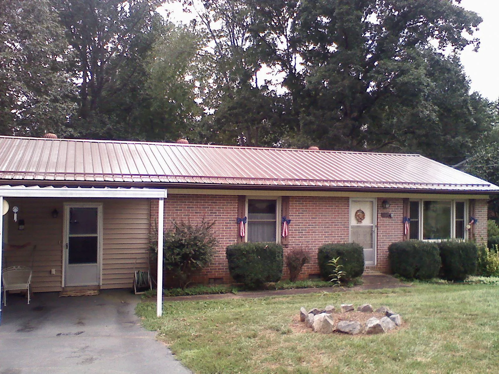 Bronze metal roof and carport on a brick ranch home — Roof Repair work by our crew in South Milford
